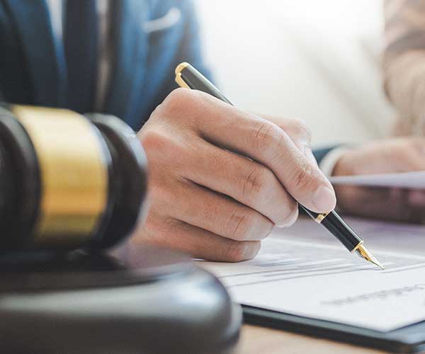 Un commissaire de justice de l'étude Margolle Barbet & Monchaux en train de signer une signification avec un client dans les Hauts-de-France à Amiens